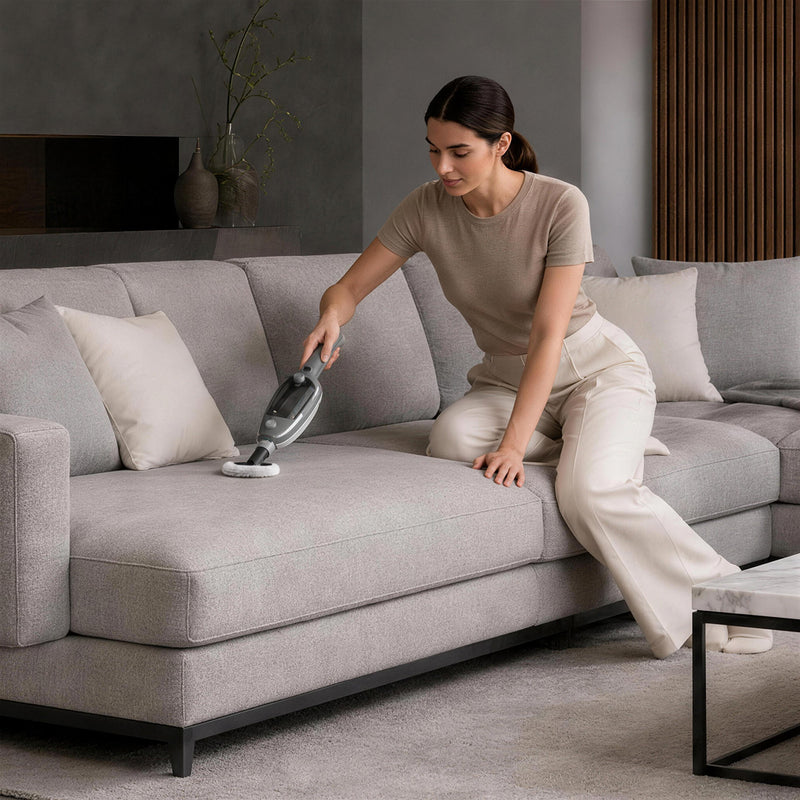 Steam cleaner nozzle cleaning a sofa